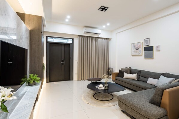 A modern living room with a sofa, coffee table, and artwork on the wall.
