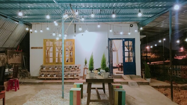 Un interior rústico con suelo de baldosas, muebles de madera y plantas en macetas.