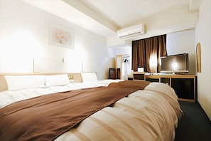 A hotel room with two beds, a TV, a desk, and an air conditioning unit. - Ginza Daiei (Tokyo)