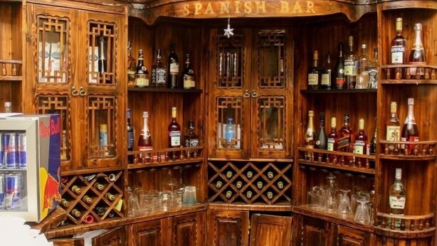 A wooden bar with a sign reading "SPANISH BAR" and various bottles and glasses. - Everyday Check Inn Limited (Port Harcourt)