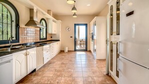 A spacious kitchen with white cabinetry, a large island, and a view to the outside. - Beautiful villa with private pool and sea views in Altea, Ref 3030 Elena Hills (Altea)