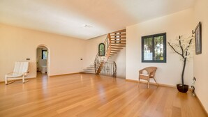 A spacious room with a wooden floor, a staircase with a wrought iron railing, and two chairs. - Beautiful villa with private pool and sea views in Altea, Ref 3030 Elena Hills (Altea)
