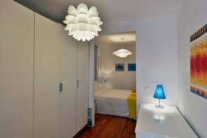A modern bedroom with a bed, bedside table, and a lamp. - FLH Norte Place (Lisbon)