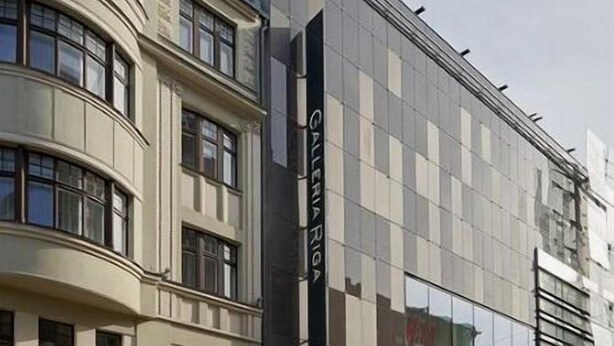 Un edificio moderno con fachada de vidrio y un cartel que dice "Galeria RIGA".