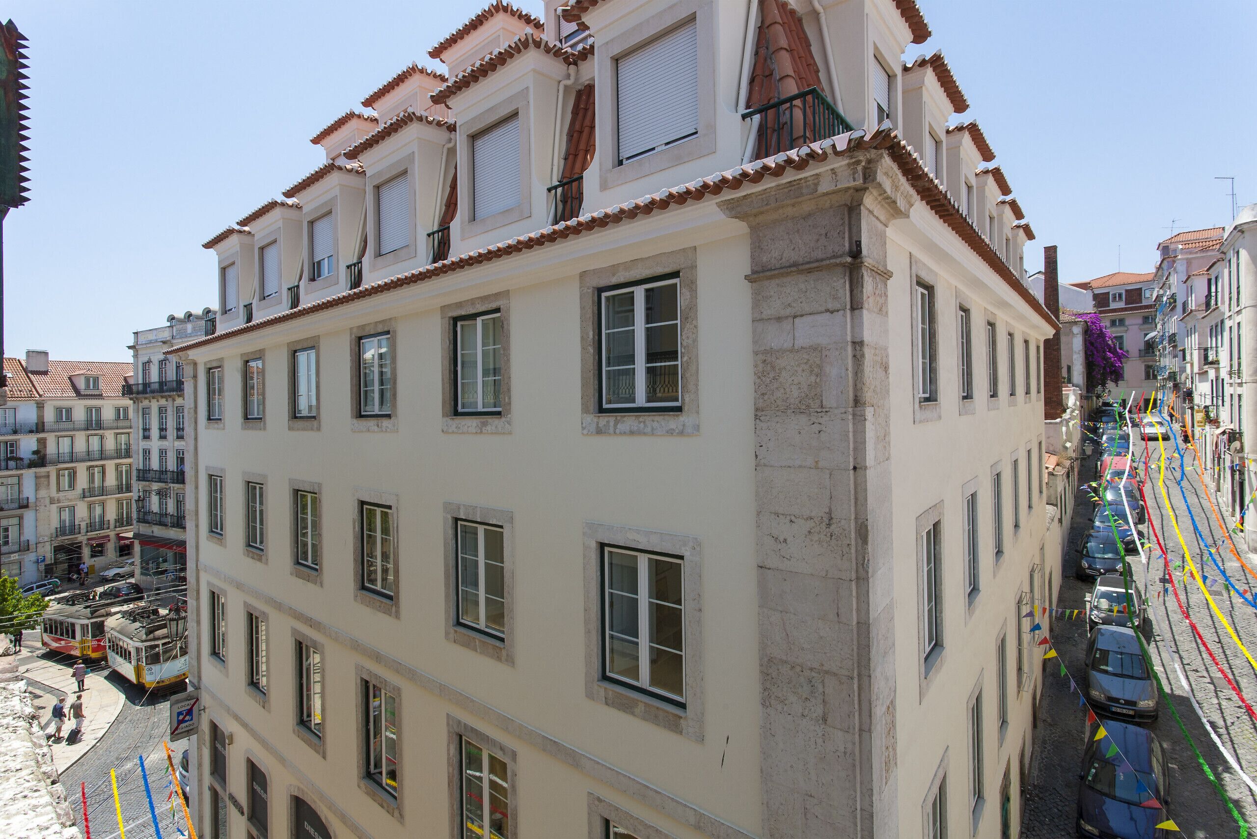 Ein mehrgeschossiges Gebäude mit klassischer Architektur, das eine Mischung aus Balkonen und Fenstern zeigt.