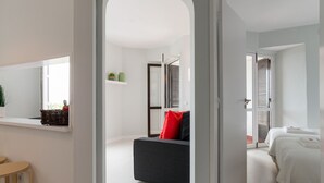 Una habitación de hotel moderna con sofá, cama y una pequeña mesa.