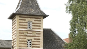 A historic building with a tower, a garage, and a well-maintained garden. - Le Clos Xavianne (Ribécourt-la-Tour)