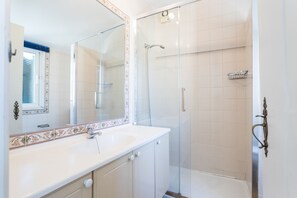 Chuveiro, secador de cabelo, toalhas de banho, shampoo