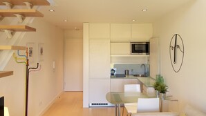 Un apartamento moderno con una escalera, una cocina y una sala de estar.