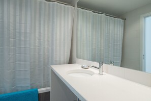 Bathtub, hair dryer, towels, toilet paper