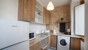 A compact kitchen with a built-in microwave, a toaster, a sink, and a washing machine. - FLH Lisbon Sun Terrace Graça III (Lisbon)