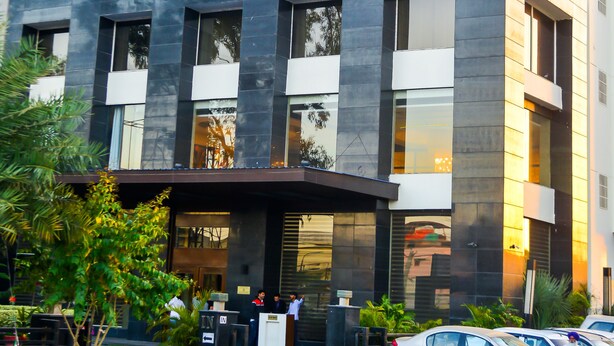 A multi-story hotel with a modern architectural design, featuring large windows and a flat roof. - Hotel Almeida (Dera Bassi)