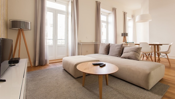 A modern living room with a sofa, a coffee table, a TV, and a lamp.