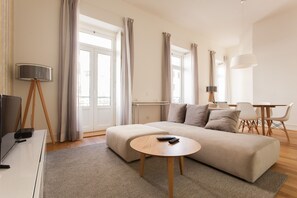 A modern living room with a sofa, a coffee table, a TV, and a lamp.