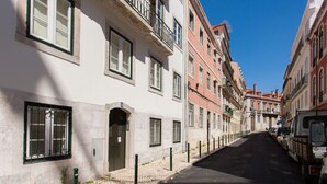 A narrow street lined with multi-story buildings, some with balconies and windows with metal bars. - FLH Príncipe Real Luxus Apartment II (Lisbon)