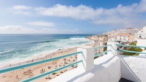 Une ville côtière avec une plage, un escalier descendant vers la plage et des bâtiments en arrière-plan.