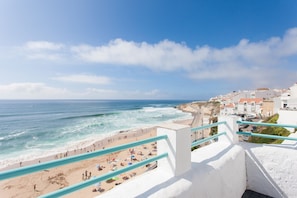 A coastal town with a beach, a staircase leading down to the beach, and buildings in the background.