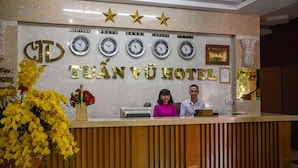 A hotel reception desk with clocks displaying times for New York, Tokyo, Hanoi, London, and Paris. - Tuan Vu Hotel (Buon Ma Thuot)