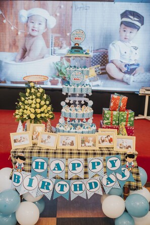 A birthday setup with a cake, gift boxes, and a 'Happy Birthday' banner.