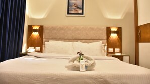 A hotel room with a large bed, two bedside tables, a painting on the wall, and a curtain on the left side. - Jewel Al Nasr Hotel & Apartments (Cairo)