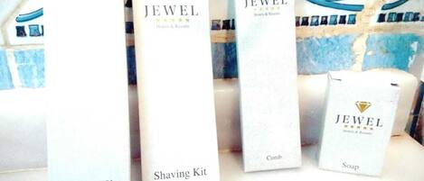 Presentación de productos de JEWEL Hotels & Resorts, que incluye un kit de higiene bucal, kit de afeitar, peine y jabón.