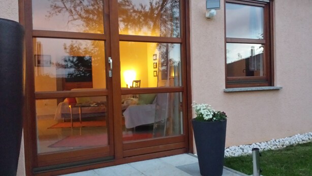 A modern house with a glass door leading to a living area. - Apartment "lake Ehmetsklinge" (Zaberfeld)