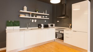 Una cocina moderna con armarios blancos, un microondas, un tostador y un horno empotrado.