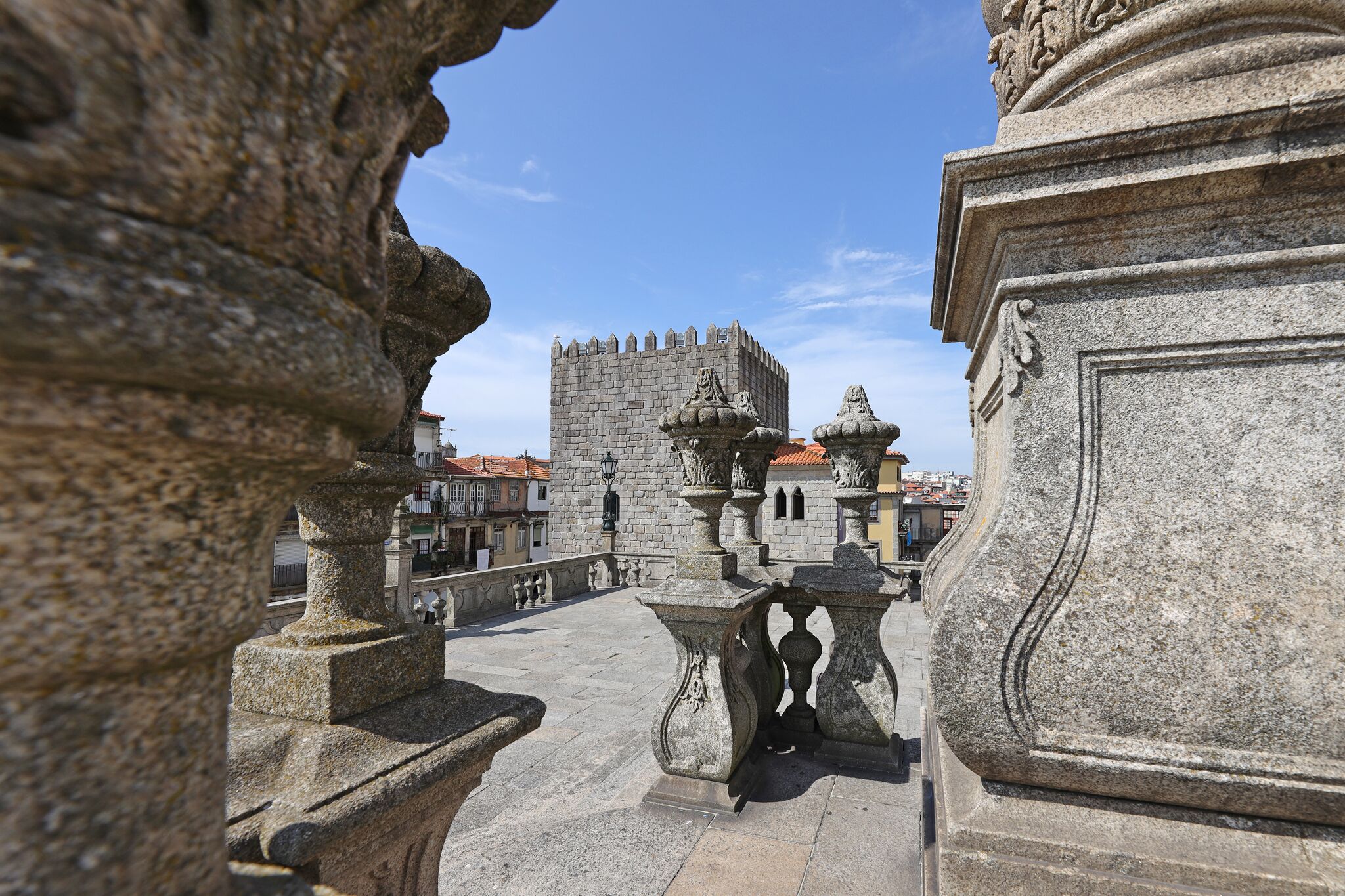 A stone bridge with ornate balustrades and a castle in the background.