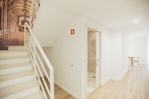 Un intérieur spacieux comprenant un escalier, une porte donnant accès à une salle de bain et un coin repas.