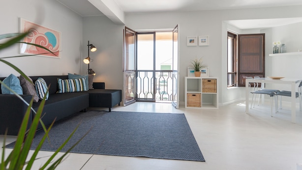 Una sala de estar moderna con un sofá, una mesa de comedor y una zona de cocina.