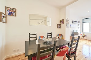 Un comedor con una mesa de madera oscura, cuatro sillas y un cuenco decorativo como centro de mesa.