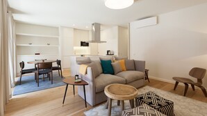 A modern living room with a sofa, coffee table, and dining area. - FLH Amazing Bairro Alto Flat (Lisbon)