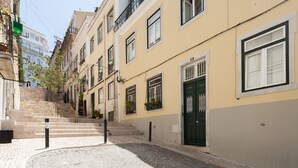 A narrow cobblestone street flanked by buildings with balconies and windows. - FLH Bica Modern Flat with View (Lisbon)