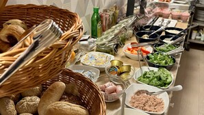 A buffet setup with various food items and utensils. - Christina Residence (Budapest)
