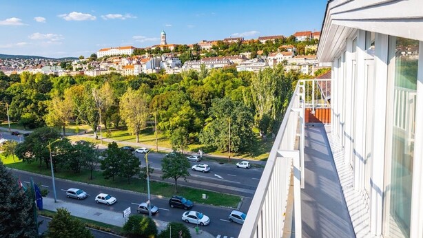 A balcony with a view of a cityscape, including buildings and a road with cars. - Christina Residence (Budapest)