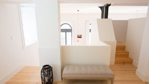 A modern interior with a wooden floor, a bench, and a black vase. - FLH Santa Catarina Modern Place (Lisboa ciudad)