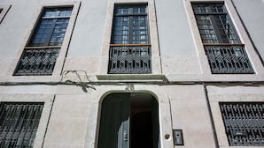 A building facade with three windows, each with decorative iron grilles and a central door with a number plaque. - FLH Santa Catarina Modern Place (Lisboa ciudad)