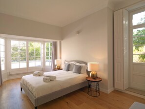 A bedroom with a bed, two bedside tables, and a window with curtains.