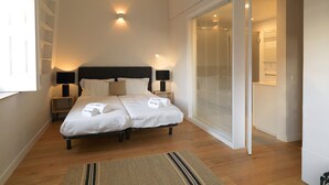 A modern bedroom with a large bed, bedside lamps, a woven ceiling light, and a sliding glass door closet. - FLH Seaside Luxury House in Porto (Oporto)