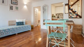 Una habitación con cama, escritorio, silla y espejo.