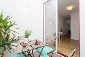 A small dining area with a wooden table, chairs, and a potted plant.