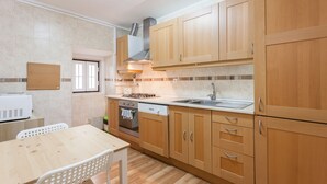 A modern kitchen with wooden cabinets, a built-in oven, a dishwasher, and a stainless steel sink. - FLH Bairro Alto Stylish Apartment (Lisbon)