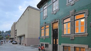 A cobblestone street with historic buildings, a scooter parked by the curb, and a clear sky. - FLH Oporto Captain House - Calem Apartment (Oporto)