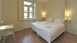 A bedroom with two beds, a desk, and a chair. - FLH Oporto Captain House - Calem Apartment (Oporto)