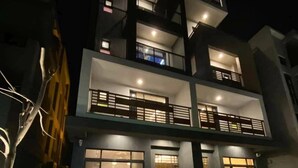 Un edificio de varios pisos con balcones, ventanas amplias y terraza.
