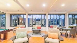 Amplio espacio interior con diversas opciones de asientos, ventanas grandes y una mesa de billar.