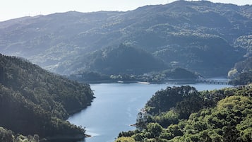 A river valley with hills, a bridge, and a small settlement.