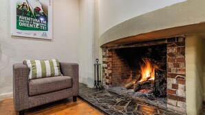 Una habitación acogedora con chimenea, un sofá y un cartel en la pared.