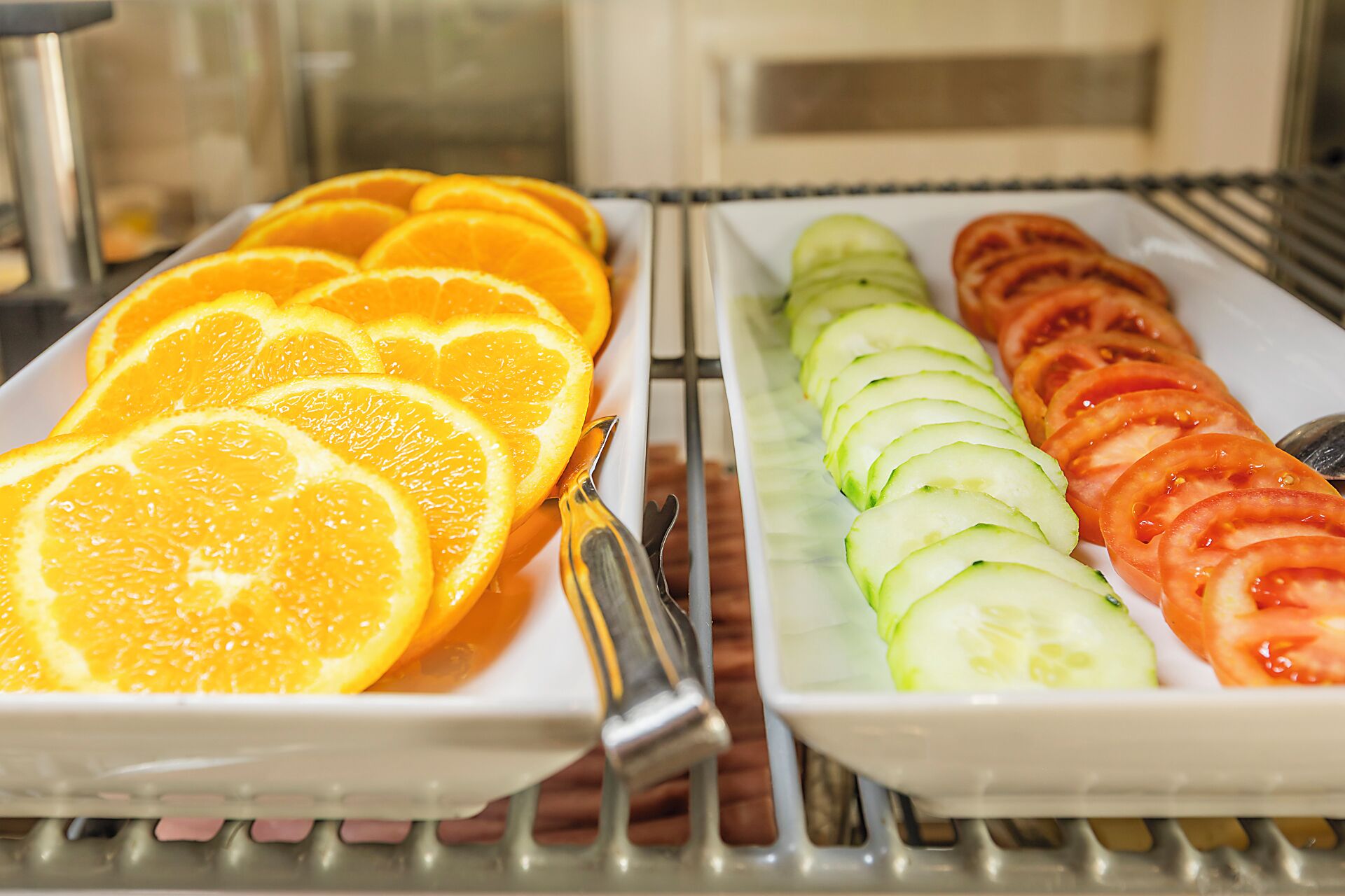 A refrigerator with trays of sliced fruits.