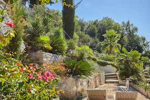 A garden with a stone wall, a staircase, and outdoor seating. - House Agave (Dubrovnik)